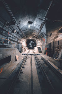 Railroad tracks in illuminated tunnel