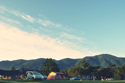 Scenic view of houses by mountains against sky