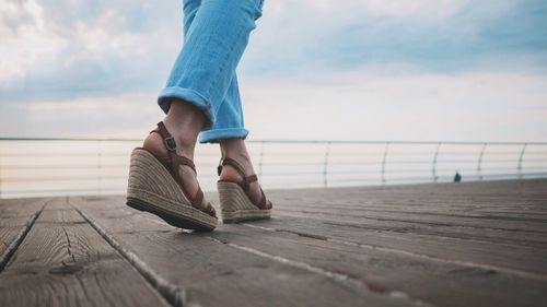 Low section of woman standing on pier