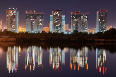 Reflection of illuminated buildings in river at night