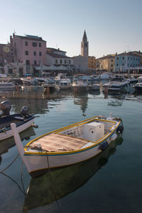 Boats moored in canal against buildings in city