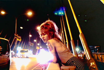 Portrait of young woman looking at illuminated table