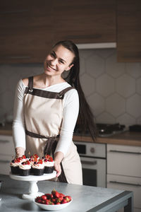 Portrait of smiling chef with cupcake kitchen