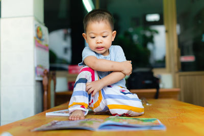 Boy with book on table at home