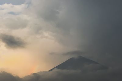 Low angle view of mountain against cloudy sky