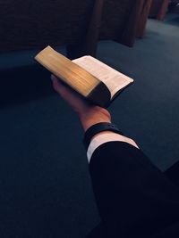 Close-up of man holding bible at church