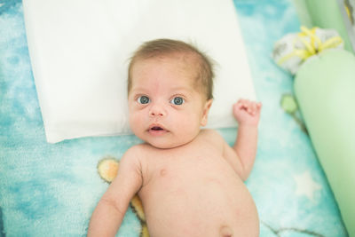 Portrait of cute baby lying on bed