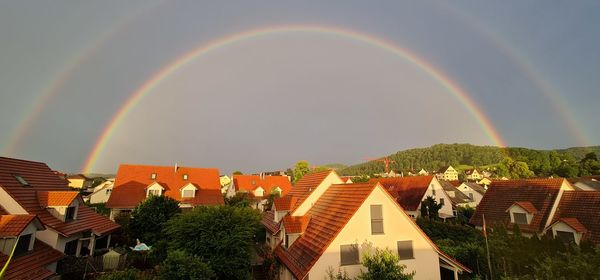 Scenic view of rainbow over buildings against sky