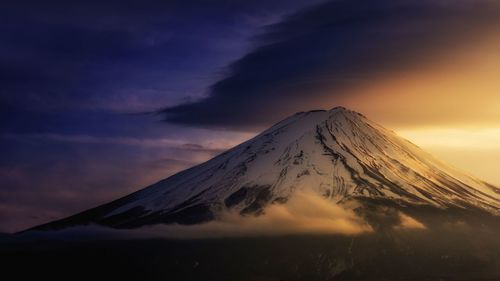 Scenic view of snowcapped mountain against sky during sunset