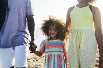 Happy girl with father and sister at beach