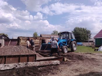 Workers working at construction site against sky