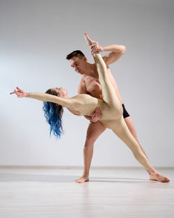 Low angle view of man dancing against white background