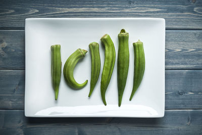 Okra on a white plate and blue table