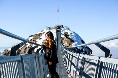 Woman on railing against sky