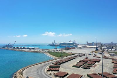 Panoramic view of harbor by sea against blue sky