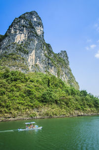 Scenic view of rocks by sea against sky