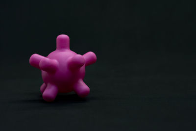 Close-up of pink toy against black background