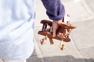 Midsection of child holding toy airplane