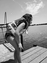 Laughing at her brother being thrown in the water