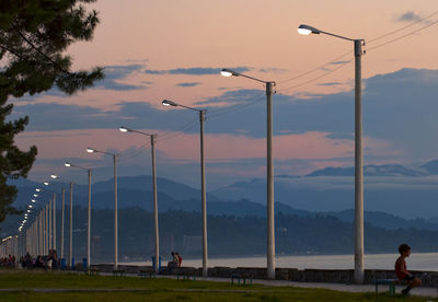 Low angle view of illuminated street lights on promenade during sunset