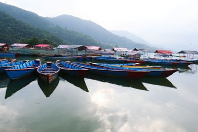 Boats moored at shore against sky