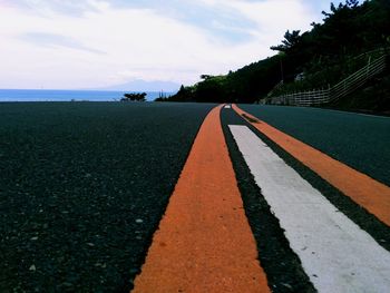 Surface level of road by sea against sky