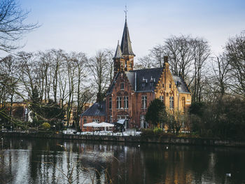 Canal by building against sky