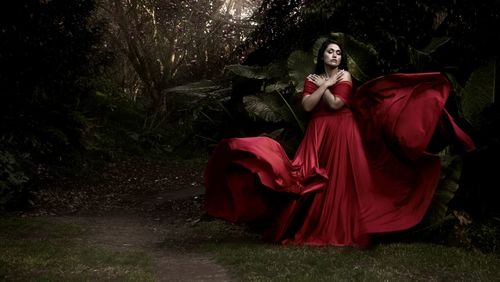 Portrait of young woman standing on field