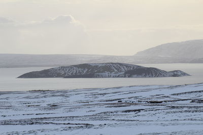 Scenic view of sea and mountains against sky