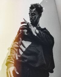 Portrait of young man standing against wall