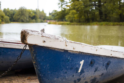 Boat moored on shore by lake