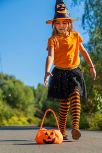 Cute girl wearing halloween costume standing on road