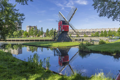 Traditional windmill by pond in city