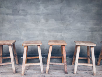 Empty chairs and table against wall