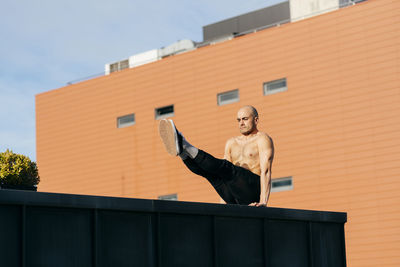 Athletic man doing parkour balance exercises outdoors in urban scene person