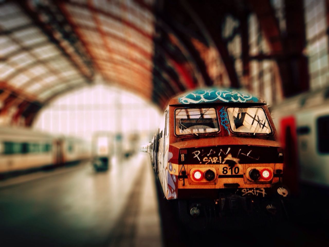 transportation, indoors, mode of transport, travel, land vehicle, public transportation, red, communication, focus on foreground, text, car, train - vehicle, blurred motion, selective focus, on the move, close-up, rail transportation, railroad station, illuminated, technology