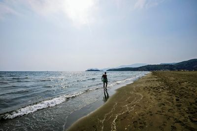 Man standing on beach against sky