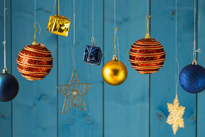 Christmas decorations hanging against blue wooden wall