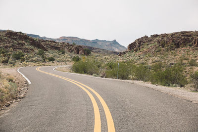 Road by mountain against clear sky