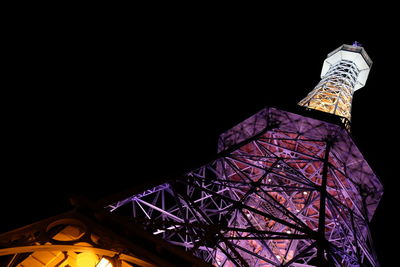 Low angle view of illuminated tower against sky at night