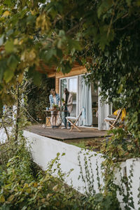 Man and woman doing gardening while standing on porch