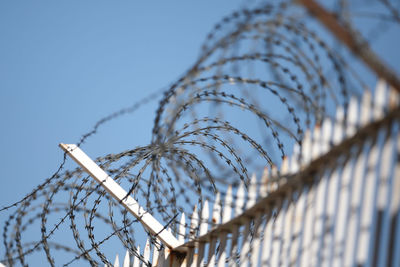 Low angle view of barbed wire against sky