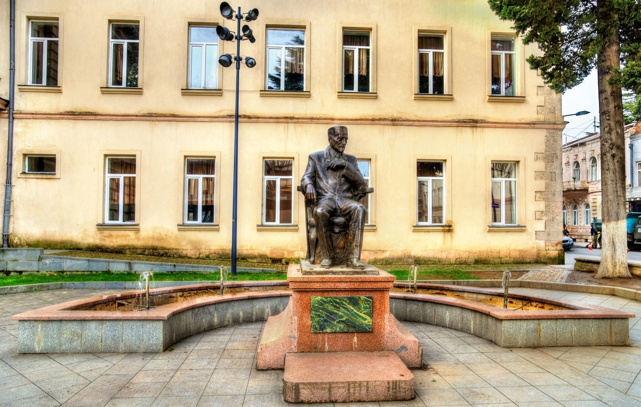 STATUE BY FOUNTAIN AGAINST BUILDING