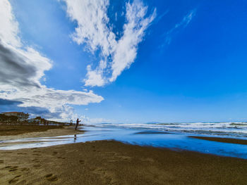 Scenic view of beach against blue sky