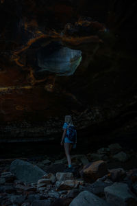 Woman walking on rock in cave