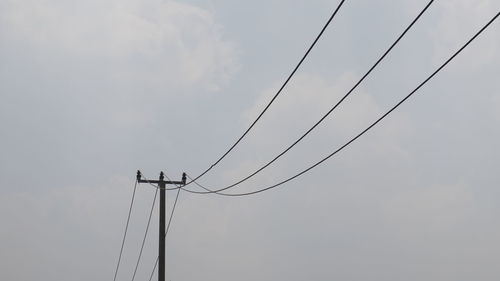 Low angle view of power line against sky