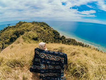 Rear view of man looking at sea against sky