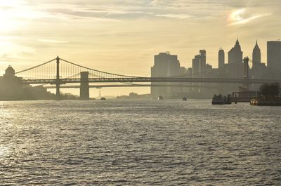 View of suspension bridge in city at sunset