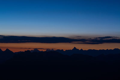 Scenic view of silhouette mountains against clear sky during sunset