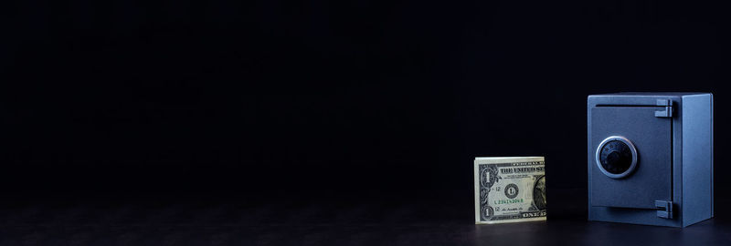 Close-up of information sign on table against black background